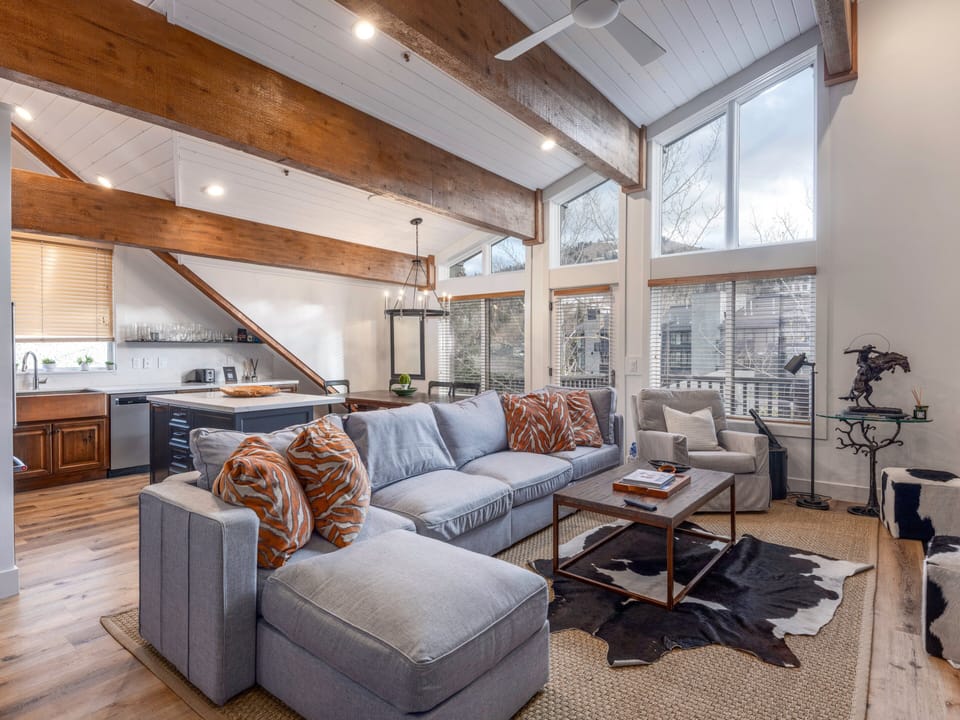 Bright open-concept living room with vaulted ceilings and cozy sectional.