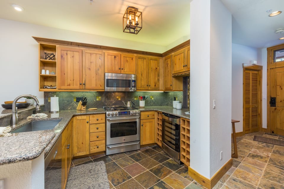 Your fully equipped kitchen features warm wood cabinets, granite countertops, and modern appliances perfect for preparing your favorite meals.