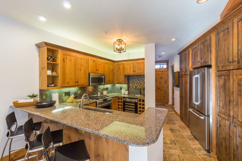 Step into your chef's paradise with warm knotty pine cabinets, granite counters, and premium appliances ready for culinary adventures.