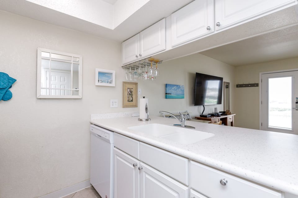 Your fully equipped kitchen features pristine white counters, ample storage, and everything you need to prepare delicious meals during your stay.