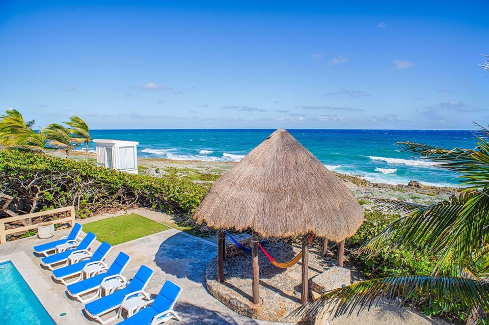 Pool area with sunbeds and palapa