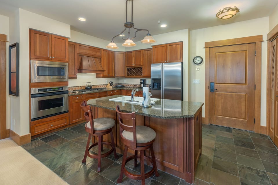 Prepare your favorite meals in this gorgeous kitchen featuring rich wood cabinets, granite counters, and top-tier stainless appliances.