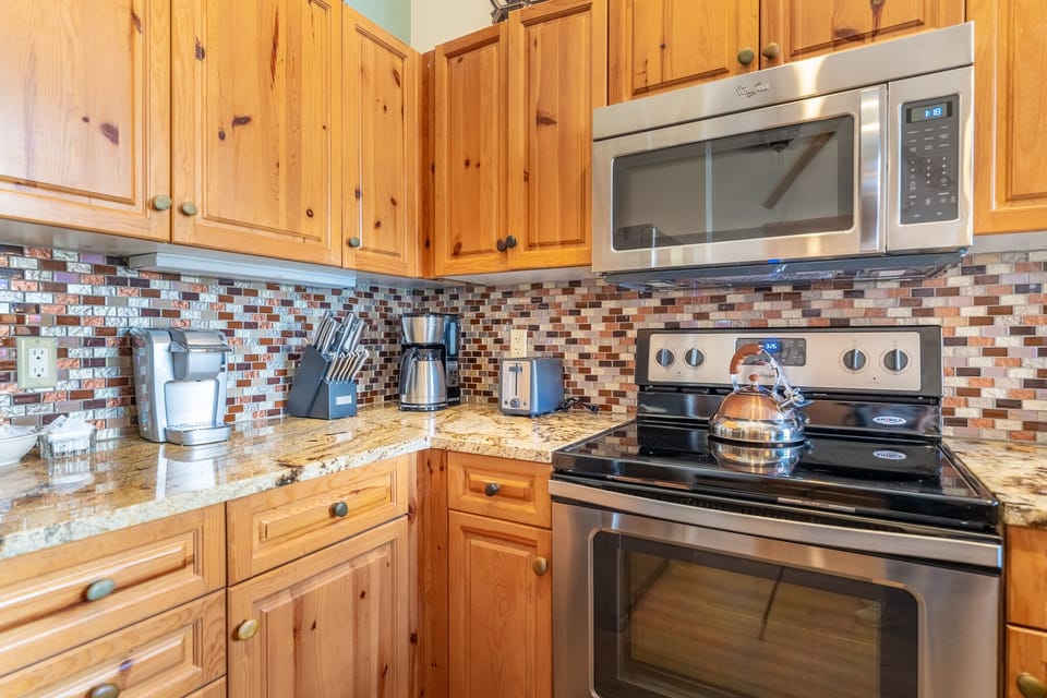 Your fully equipped kitchen features warm wood cabinets, granite countertops, and modern stainless steel appliances for all your culinary adventures.