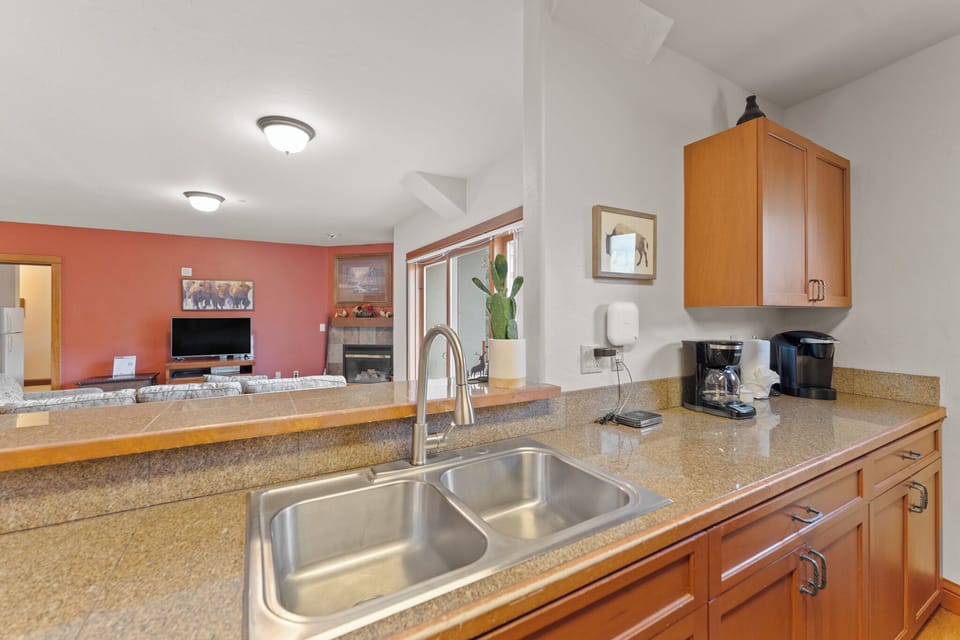 Your fully equipped kitchen features granite counters and opens to a cozy living space with fireplace—perfect for preparing meals while staying connected.