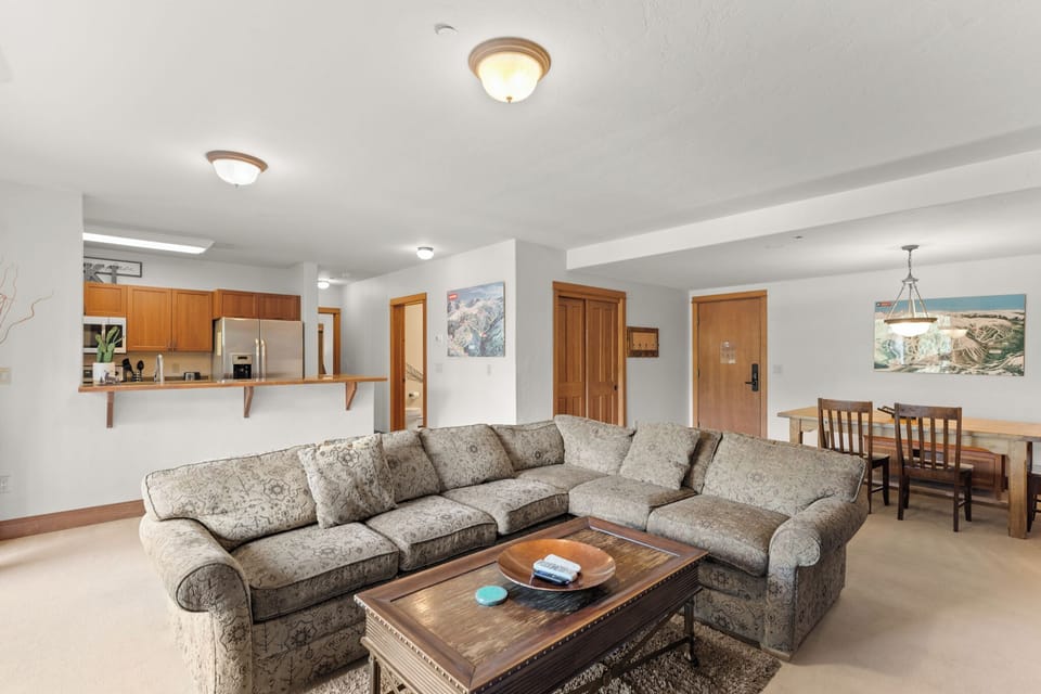 Relax in your spacious open-concept living area with plush sectional seating, fully equipped kitchen, and cozy dining space perfect for memorable gatherings.