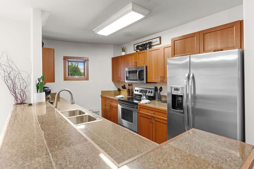 Your fully equipped kitchen features granite countertops, stainless steel appliances, and warm wood cabinets—perfect for preparing meals during your stay.