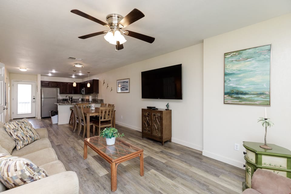 Relax in your open-concept living space where rustic wood floors meet modern comfort. Unwind on the cozy sofa while dinner simmers in your fully equipped kitchen.