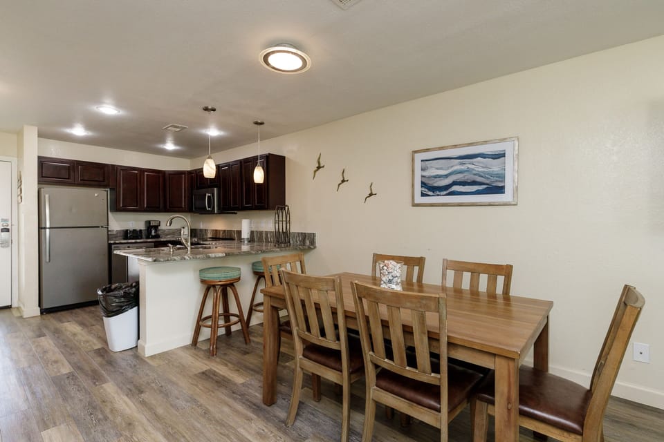 Your open kitchen and dining area blends modern convenience with coastal charm, perfect for preparing meals and gathering with loved ones.
