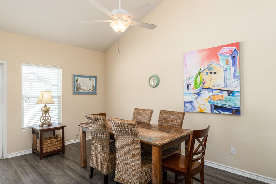 Your spacious dining room welcomes family meals with comfortable seating for six and charming coastal artwork overhead.