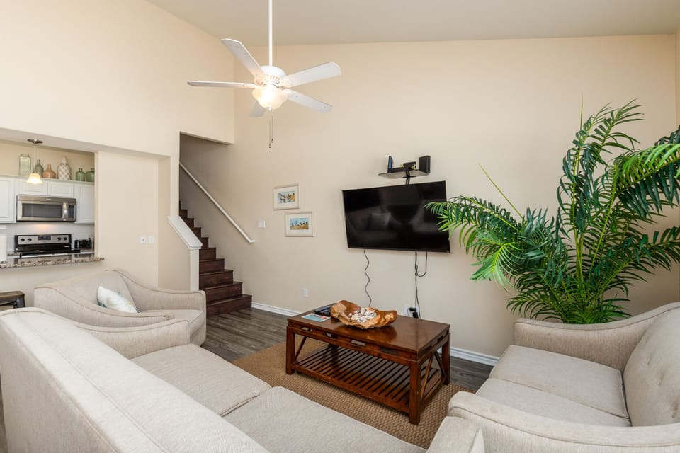 Relax in your bright living room with plush seating, ceiling fan, and TV for cozy evenings in.