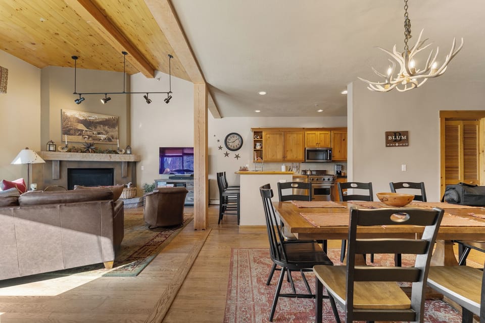 Your open-plan living space features rustic wood beams, a cozy fireplace, and a fully equipped kitchen where family meals become cherished memories.