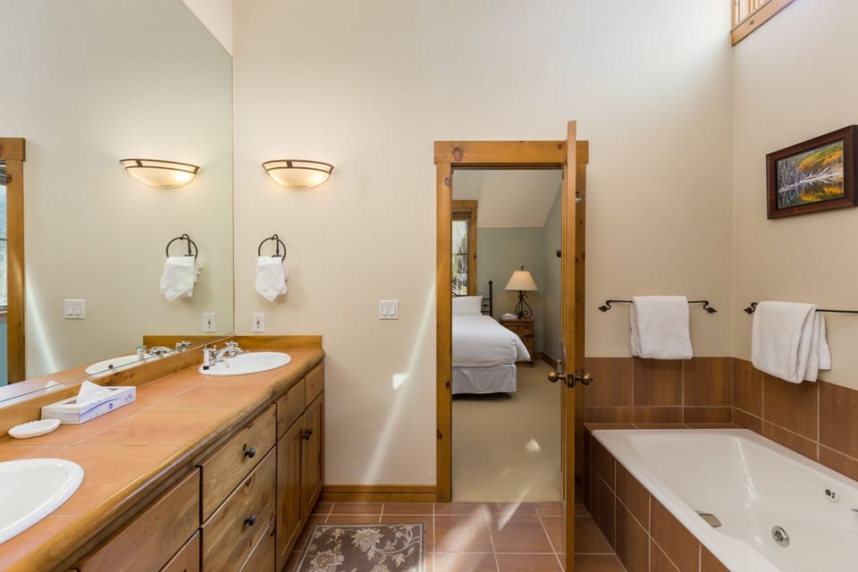 Soak in your private spa-style bathroom with dual vanities, warm lighting, and a luxurious soaking tub.