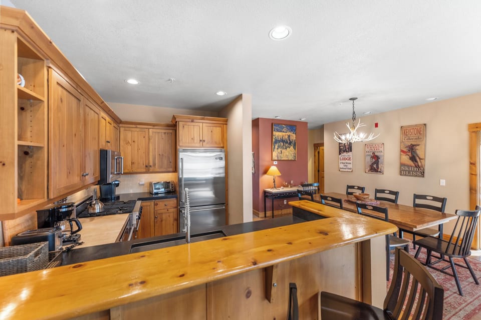 Your spacious kitchen features rustic wood cabinets, granite counters, and stainless steel appliances, flowing seamlessly into the dining area.