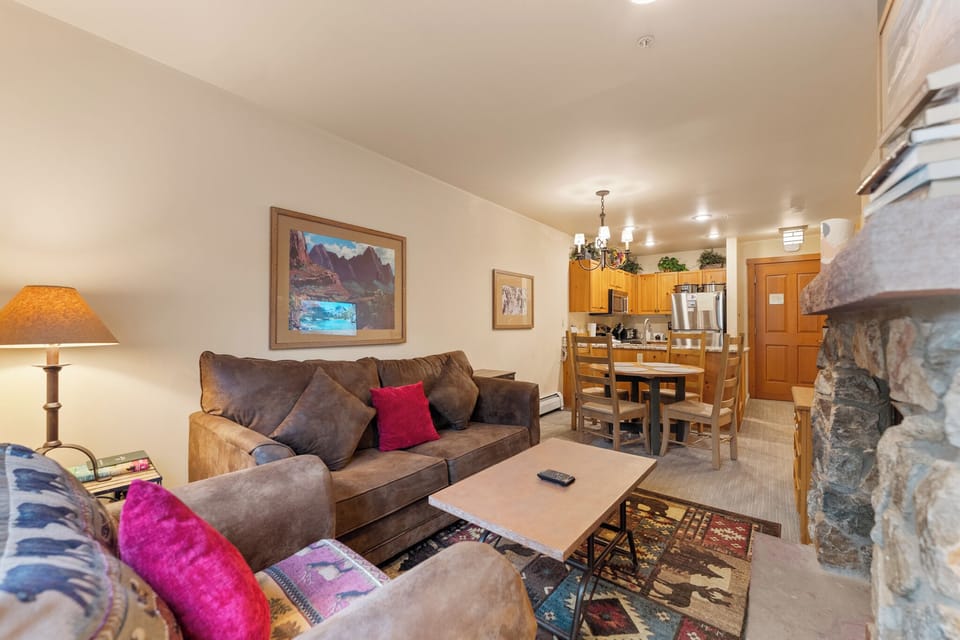 Sink into plush sofas by your stone fireplace, where mountain art and warm lighting create the perfect retreat after exploring.