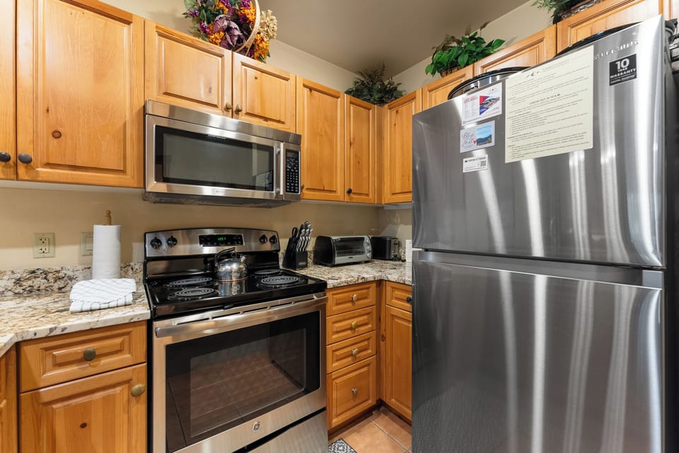 Your fully equipped kitchen features stainless steel appliances, granite countertops, and warm wood cabinetry for all your cooking needs.