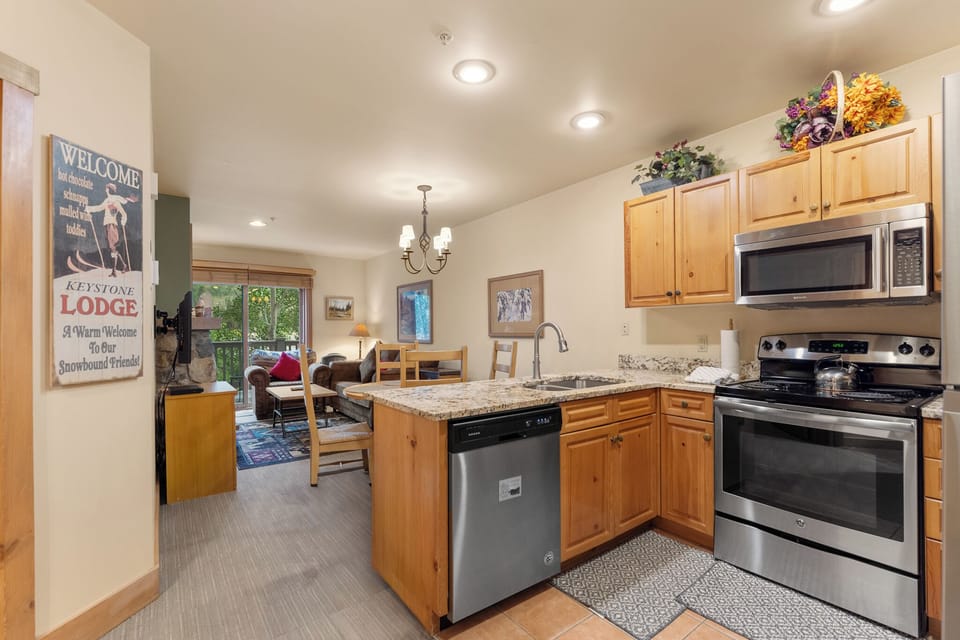 Your fully equipped kitchen flows seamlessly into the cozy living space, perfect for preparing meals while staying connected with loved ones relaxing nearby.