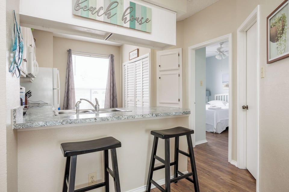 Your bright kitchenette features granite counters and bar seating, perfect for morning coffee or quick meals before beach adventures.