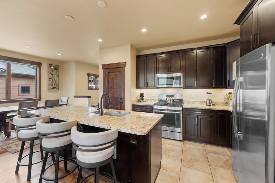 Your modern kitchen awaits with granite counters, stainless steel appliances, and a breakfast bar perfect for morning coffee.