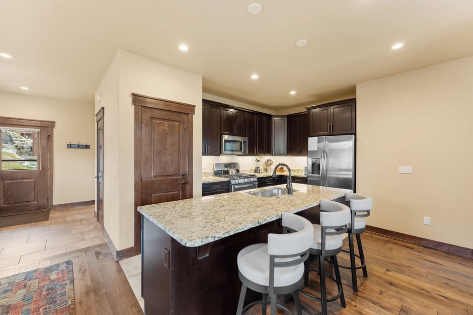 Your gourmet kitchen awaits with granite countertops, stainless appliances, and a spacious island perfect for morning coffee or evening conversations.