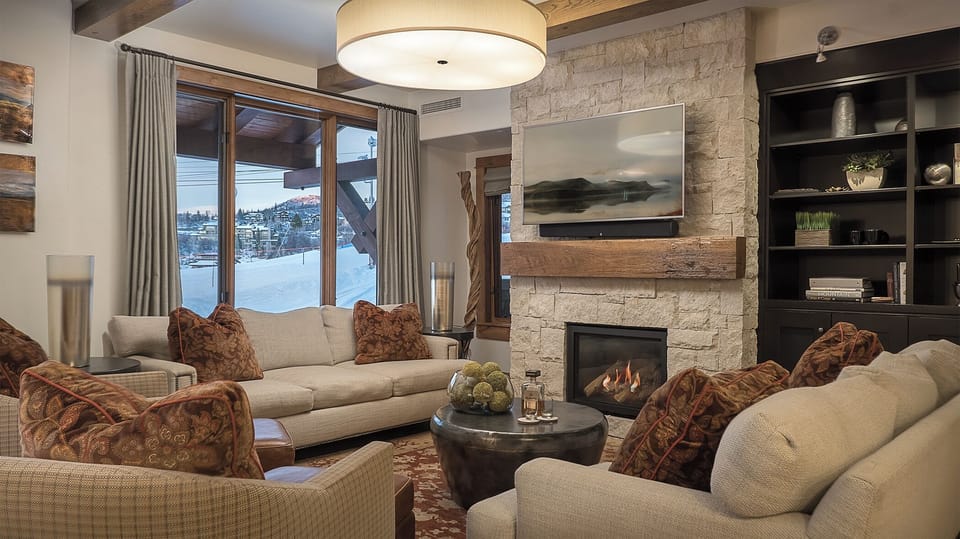 Sink into plush seating by your crackling fireplace while mountain views frame your perfect winter retreat.