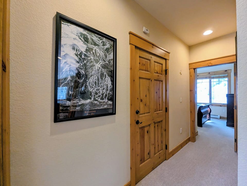 Move through your private hallway with beautiful mountain artwork and rustic wood doors leading to comfortable living spaces.