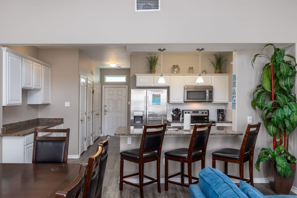 Your open kitchen features stainless appliances, granite counters, and breakfast bar seating for memorable meals together.