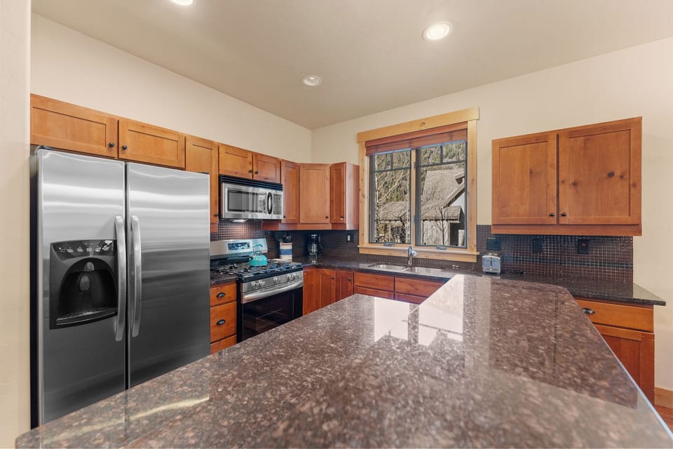 Your fully equipped kitchen awaits with granite counters, stainless appliances, and warm wood cabinets for memorable meal prep.
