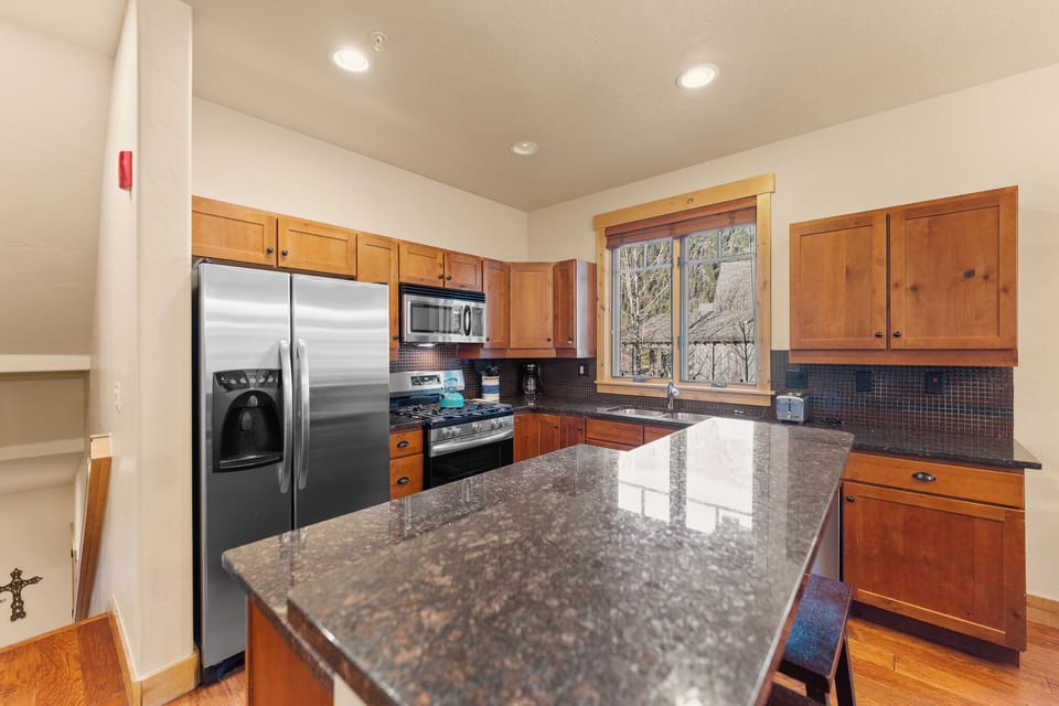 Your fully equipped kitchen awaits with granite counters, stainless appliances, and warm wood cabinets for memorable meal preparation.