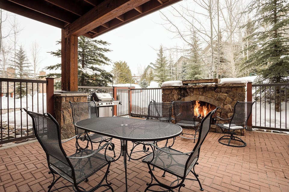 Cozy up by your private outdoor fireplace while grilling dinner on your covered patio, surrounded by snow-dusted trees.