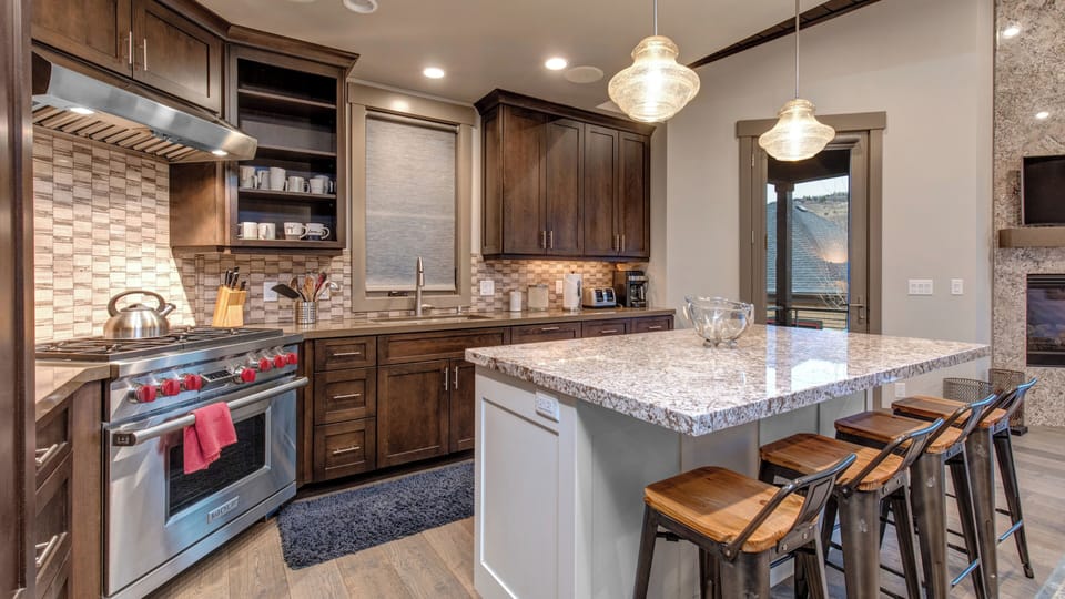 Enjoy cooking in the stylish, fully-equipped kitchen with a large central island, granite countertops, and modern amenities.