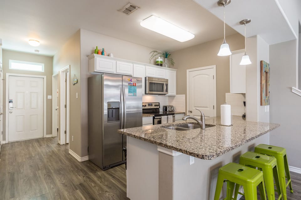 Your fully equipped kitchen features granite countertops, stainless steel appliances, and a breakfast bar where you can enjoy morning coffee together.