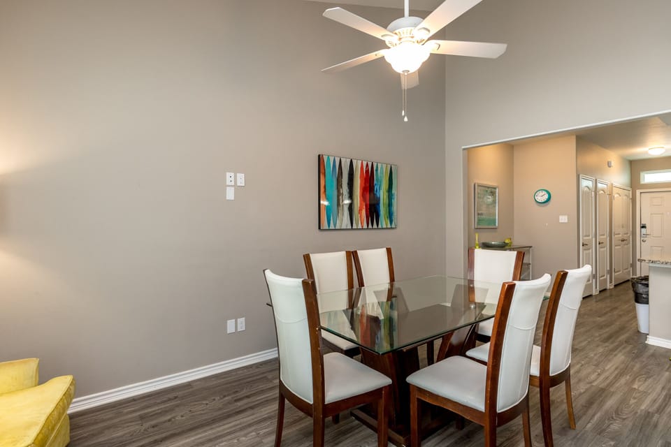 Gather around your elegant glass dining table for memorable meals with loved ones in this sophisticated space.