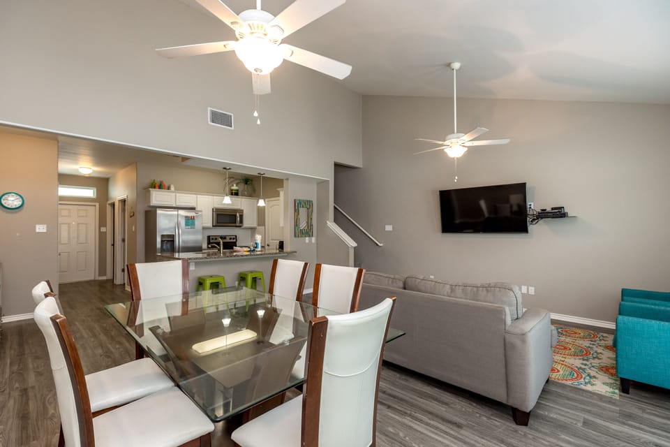 Relax in your spacious open-concept living area with comfortable seating, elegant dining table, and modern kitchen—perfect for memorable meals together.