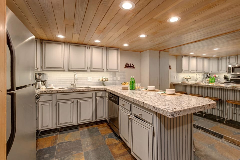 Fully equipped kitchen offering gorgeous quartz counters and stainless steel appliances, and bar with seating for up to four people