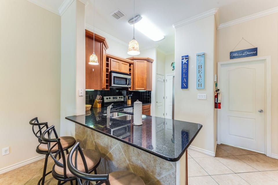 You'll love preparing meals in this bright kitchen with granite counters, warm wood cabinets, and breakfast bar seating for casual dining.
