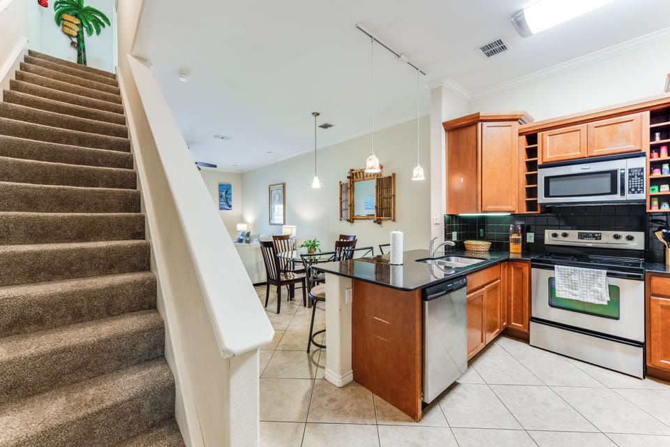 Your open-concept kitchen flows seamlessly into the dining area, where warm wood cabinets and granite counters invite you to cook memorable meals together.