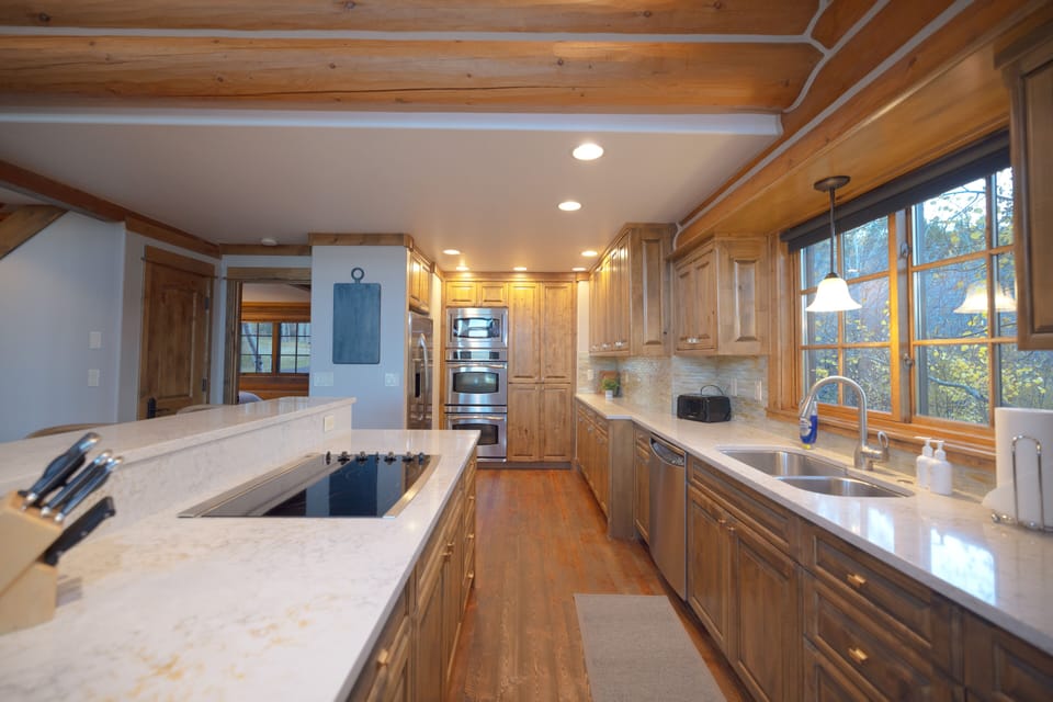 Your dream kitchen awaits with warm wood cabinetry, gleaming countertops, and natural light streaming through large windows. Cook with joy using premium appliances while enjoying mountain views.