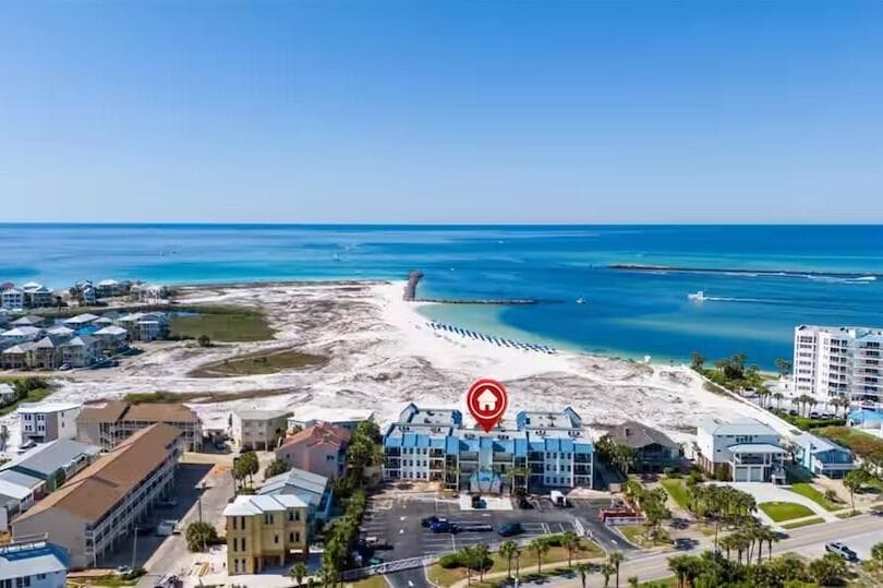 Aerial view showcasing the property's prime beachfront location on Florida's stunning emerald coast, with pristine white sand beaches and turquoise Gulf waters just steps away.