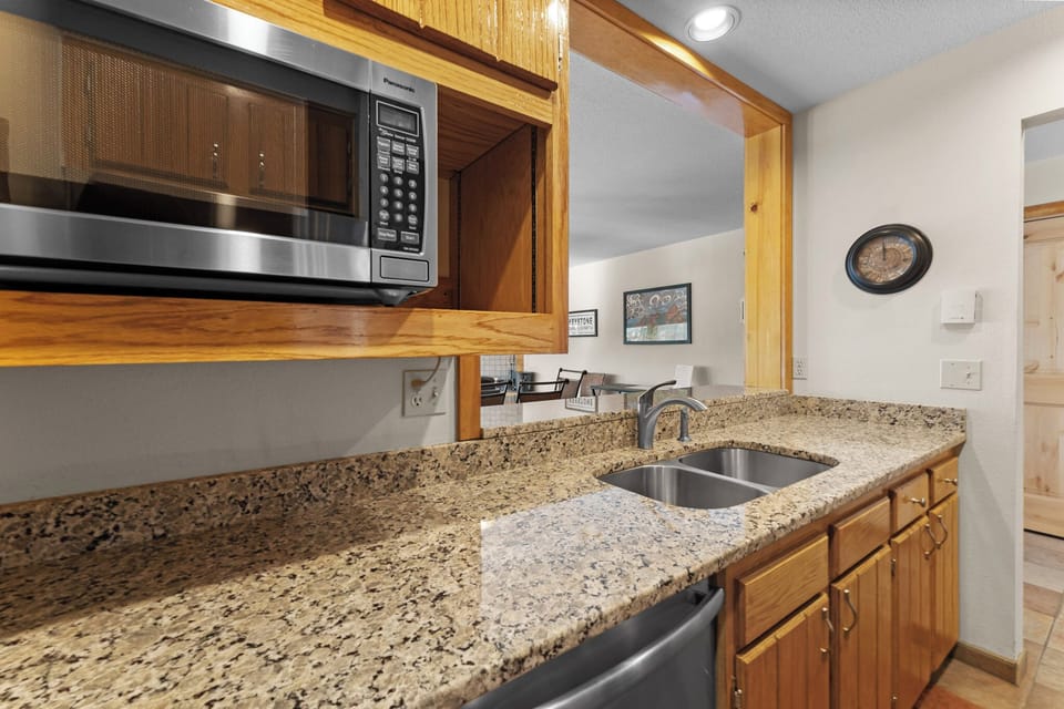 Your fully equipped kitchen features granite countertops, stainless steel appliances, and warm wood cabinetry for all your culinary needs.