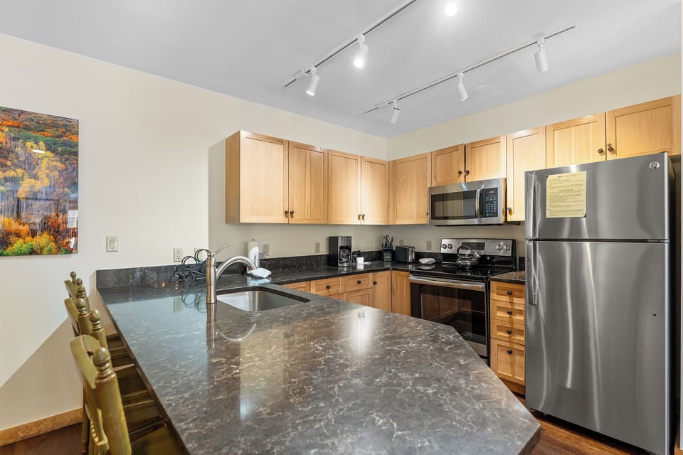 Your fully equipped kitchen features granite countertops, stainless steel appliances, and warm wood cabinets for effortless meal preparation.