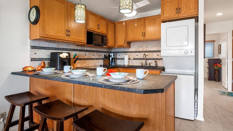 he kitchen is fully equipped with a cooktop, full-size refrigerator, toaster/convection oven