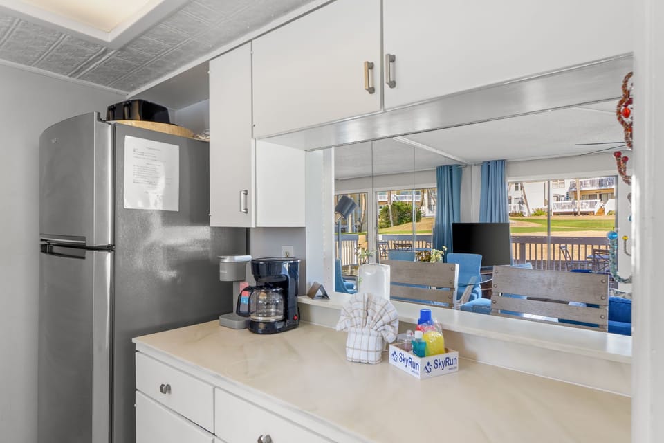 Enjoy the kitchen coffee station and open pass-through design connecting the kitchen to the living area. A bright, welcoming space perfect for morning coffee, casual meals, and easy gathering throughout your stay.