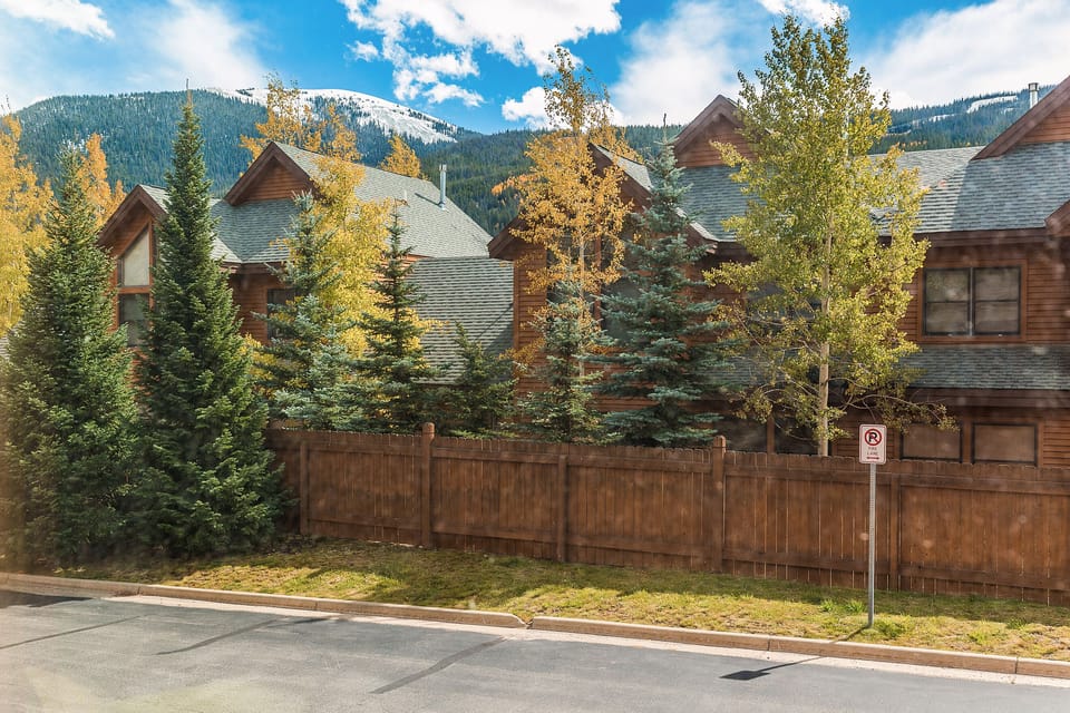 Mountain townhomes nestled among golden aspens with snow-capped peaks creating a stunning alpine backdrop for your stay.