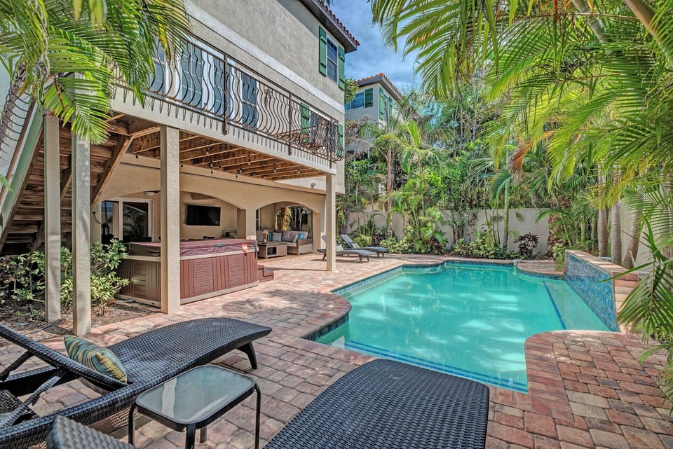 Pool deck with view of heated pool along with hot tub. Accompmanied by a pool lounge chairs and plenty of seating