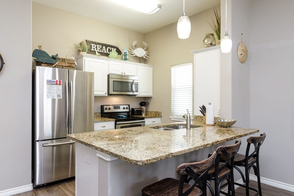 Your fully equipped kitchen features granite countertops, stainless appliances, and charming beach-themed touches that make cooking a delightful coastal experience.