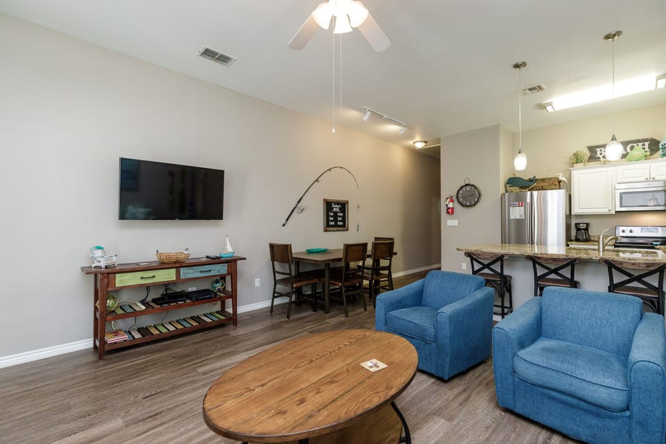 Relax in your spacious open-concept living area with comfortable seating, modern kitchen, and entertainment setup for memorable evenings together.
