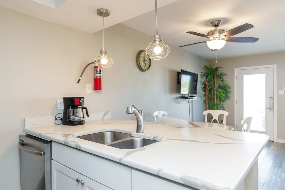 Your modern kitchen features sleek white countertops, stainless steel appliances, and stylish pendant lighting for memorable meal prep moments.