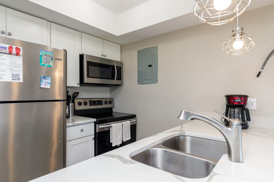 Your fully equipped kitchen features stainless steel appliances, granite countertops, and modern pendant lighting for memorable meal preparation.