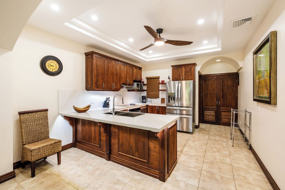 Beachfront condo kitchen in Playa Langosta with granite counters, breakfast bar, and tropical design. Costa Rica vacation rental near Tamarindo offering open layout, family‑friendly comfort, and stylish space for cooking steps from the beach. 