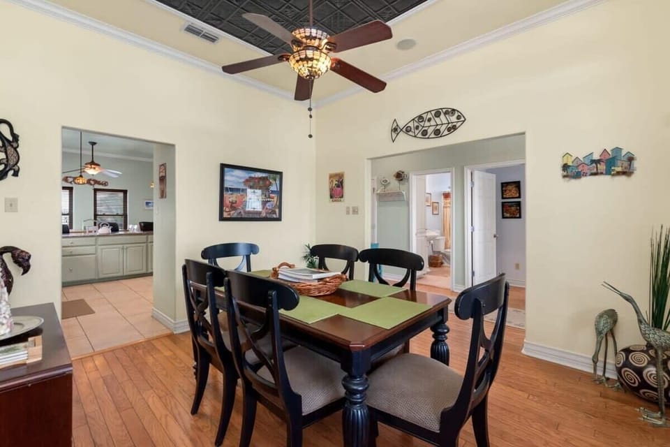 Formal dining room — view toward kitchen and hallway with beach artwork
